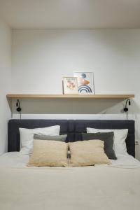 a bed with a blue headboard and white pillows at Zoder Apartments in Vienna
