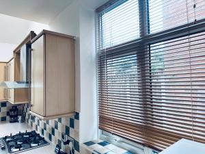 una cocina con una ventana grande con persianas. en Impeccable 3-Bed House in Nottingham Central en Nottingham