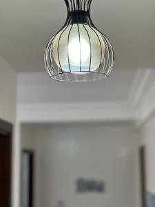 a glass light fixture hanging from a ceiling at New apartment, fully equipped in Ville Nouvelle
