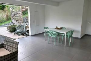 una sala da pranzo con tavolo e sedie bianchi di Appartement Pyé koko a Lamentin