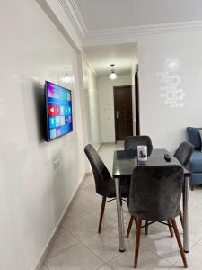 comedor con mesa, sillas y TV en New apartment, fully equipped, en Ville Nouvelle