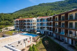 an apartment building with a pool and mountains in the background at Casa Collection in Tivat