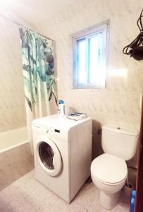 a bathroom with a washing machine and a toilet at te amo apartamento in Madrid