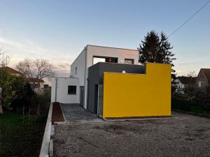 ein weißes und gelbes Haus mit gelber Wand in der Unterkunft Près Colmar 6 bis 