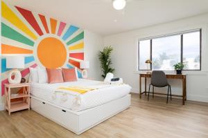 a bedroom with a bed with a colorful wall at Be A Nomad Lovely 2br 1blk from the Ocean in Jacksonville Beach +41 photos