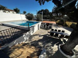 una piscina con 2 bancos y un árbol en Vivienda La Colina en Córdoba