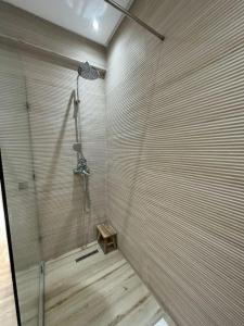 a bathroom with a shower with a wooden floor at Luxury, Cosy Apartement (Wifi, Balcony, Parking) in Marrakech