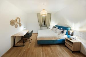 a bedroom with a blue bed and a desk at Zoder Apartments in Vienna