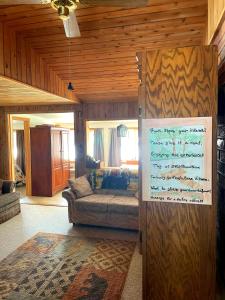 a living room with a couch and a sign on a wall at Sandy Hollow Vacation Home in White
