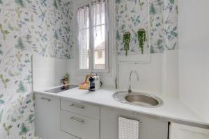 eine Küche mit Spüle und Fenster in der Unterkunft Studio cosy proche Paris, Stade de France in Pierrefitte-sur-Seine + 15 Fotos