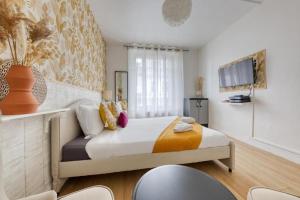 - une chambre avec un lit et une télévision murale dans l'établissement Studio cosy en centre-ville Proche de Paris, à Pierrefitte-sur-Seine