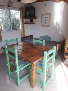 a wooden table and chairs in a room at Departamentos Serranos en Tandil in Tandil