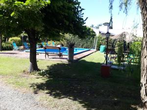a park with a swimming pool with a bench and trees at Departamentos Serranos en Tandil in Tandil