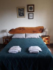 a bedroom with a bed with two towels on it at Departamentos Serranos en Tandil in Tandil