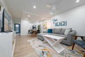 a living room with a couch and a tv at Be A Nomad Lovely 2br 1blk from the Ocean in Jacksonville Beach