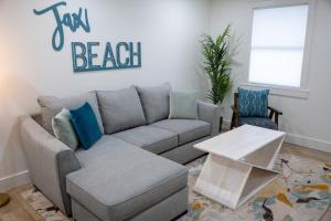 a living room with a couch and a table at Be A Nomad Lovely 2br 1blk from the Ocean in Jacksonville Beach