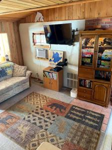 a living room with a couch and a tv at Sandy Hollow Vacation Home in White