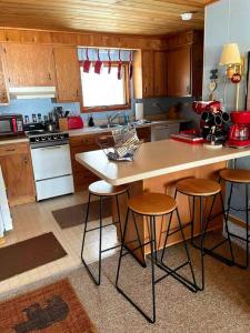 a kitchen with a counter and stools in it at Sandy Hollow Vacation Home in White