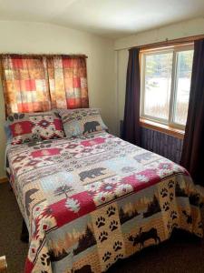 a bedroom with a bed with a quilt on it at Sandy Hollow Vacation Home in White