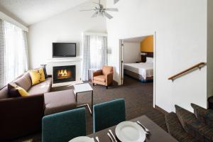 Residence Inn Anaheim Placentia/Fullerton في بلاسنتيا: غرفة معيشة مع أريكة ومدفأة
