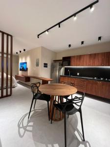 une cuisine avec une table et des chaises dans une pièce dans l'établissement Studio Beira Mar de Tatuamunha, Rota dos Milagres, à Porto de Pedras