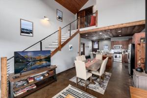 a living room with a dining room table with a tv at The Bross Ranch Cabin - Open Floor Plan! 10Mi to Ski Breck! Hot Tub! in Fairplay