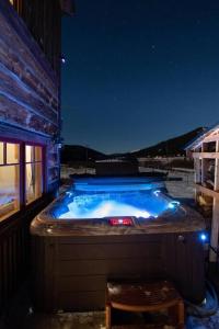 a hot tub sitting outside of a building at night at The Bross Ranch Cabin - Open Floor Plan! 10Mi to Ski Breck! Hot Tub! in Fairplay