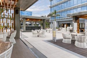 un patio con sillas y mesas blancas y un edificio en Courtyard by Marriott Iloilo, en Iloilo City