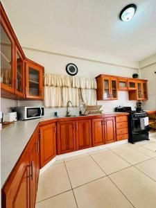 a kitchen with wooden cabinets and a stove top oven at Alto Prado Chocolate in Gwa Kay