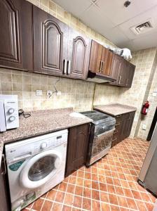 a kitchen with a washer and dryer in it at Peaceful Partition Room Near Mall of the Emirates in Dubai