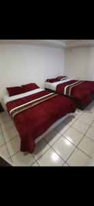 Cette chambre dispose de deux lits installés sur un sol carrelé. dans l'établissement Estancia la Ocho, à Tijuana