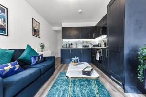 Stylish and Family Friendly 3 Bedroom Apartment في لندن: غرفة معيشة مع أريكة زرقاء وطاولة