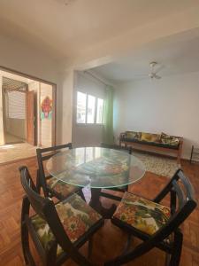 a dining room with a glass table and two chairs at Carnaval in Barra in Salvador