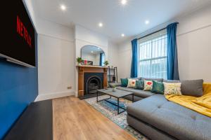 a living room with a couch and a tv at West London Period House in London