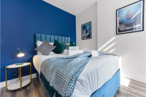 Lovely Two Bedroom with Ensuite Bathrooms في لندن: غرفة نوم زرقاء وبيضاء مع سرير