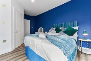 1 dormitorio azul con 1 cama grande y paredes azules en Lovely Two Bedroom with Ensuite Bathrooms, en Londres