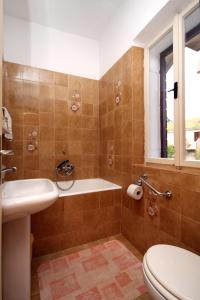 a bathroom with a tub and a toilet and a sink at Apartments with a parking space Vrisnik, Hvar - 8733 in Jelsa