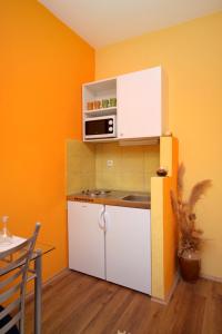 a small kitchen with a white cabinet and a microwave at Apartments with a parking space Vrisnik, Hvar - 8733 in Jelsa