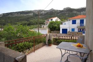 a balcony with a table with fruit on it at Apartments with a parking space Vrisnik, Hvar - 8733 in Jelsa