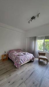 a bedroom with a bed and a chair and a window at Departamento en glamourosa calle, 1 dormitorio in Buenos Aires