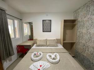 a bedroom with a bed with two swans towels on it at Pousada Residência dos Sonhos in Porto De Galinhas +101 photos