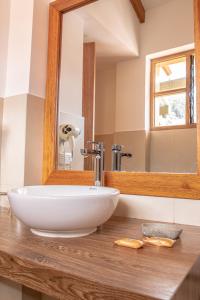 ein Badezimmer mit einem weißen Waschbecken und einem Spiegel in der Unterkunft Amaru Inca in Cusco