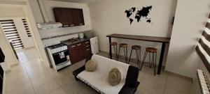 cocina con sofá, mesa y fogones en Departamento Fuegia en Ushuaia
