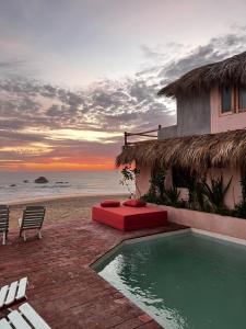 a house with a swimming pool next to the beach at Sebastian de los milagros in Zipolite