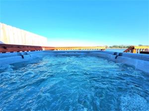 a large swimming pool with blue water in it at Marsh House, HOT TUB, Waterfront, KING bed, Close to Lejeune, in Cedar Point