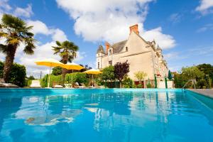 a swimming pool in front of a house at Château de la Verie in Challans