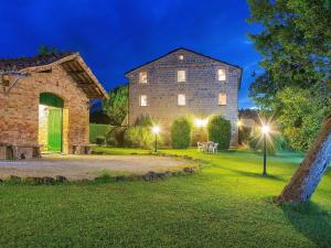a large stone building with lights on the lawn at Spacious Holiday Home in Amandola with Swimming Pool in Amandola