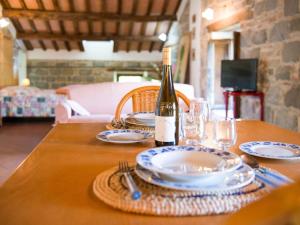 a table with a bottle of wine and plates on it at Spacious Holiday Home in Amandola with Swimming Pool in Amandola