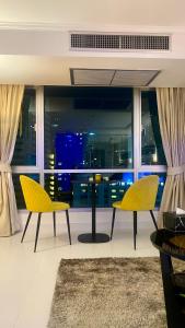 a living room with two yellow chairs and a window at Sukhumvit13 Luxury suite in Bangkok