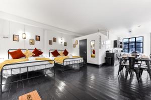two beds in a room with a table and chairs at Trendy and Eccentric Flat in Hackney in London